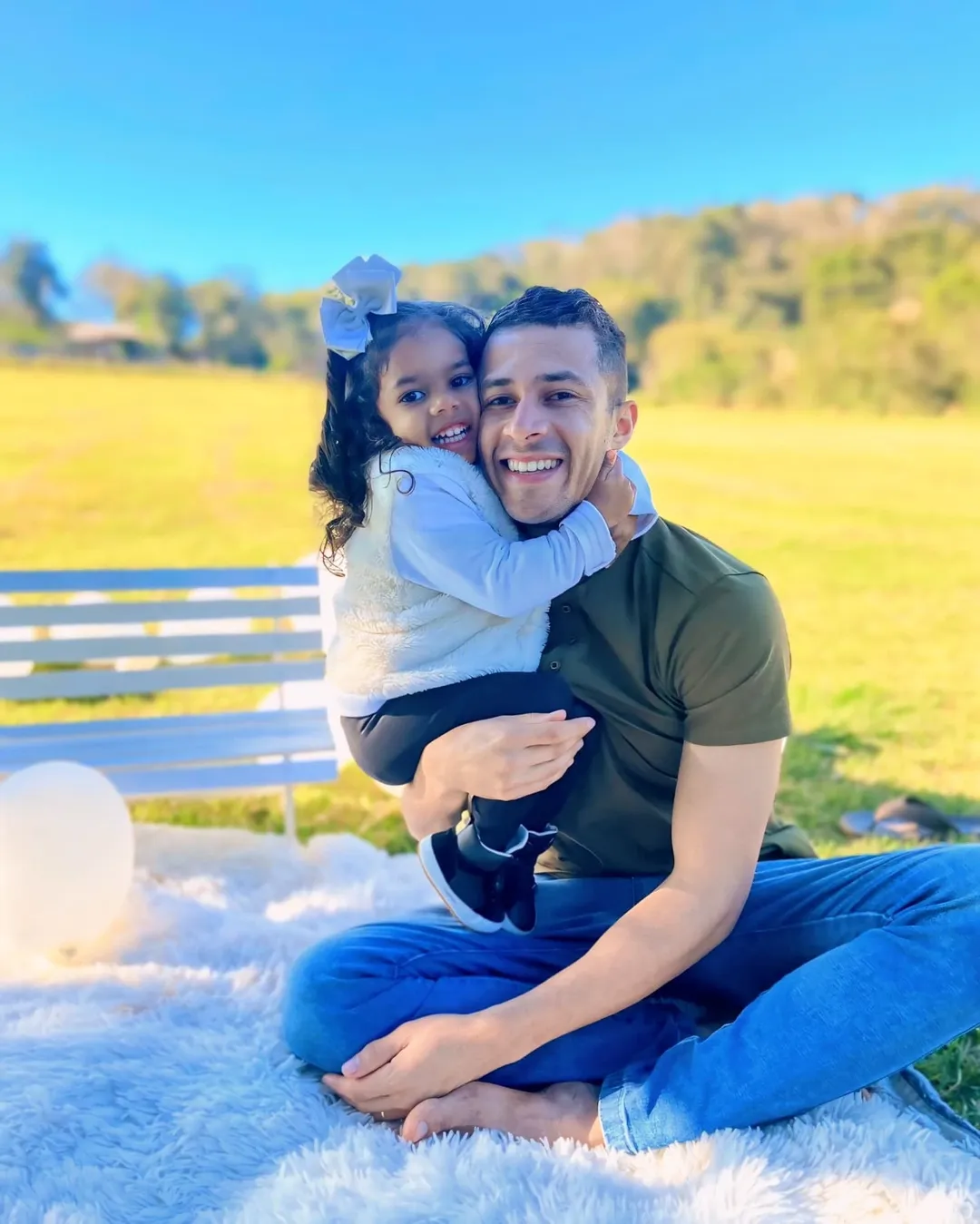 Pai abraçando a filha ao ar livre, momento de afeto